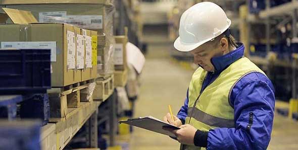 Custom house agent checking cargo in a warehouse